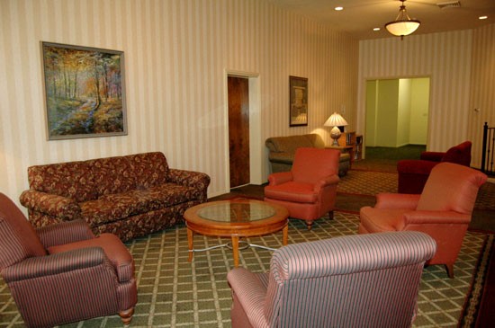 Fairmont lounge room with chairs and couches, stripped walls